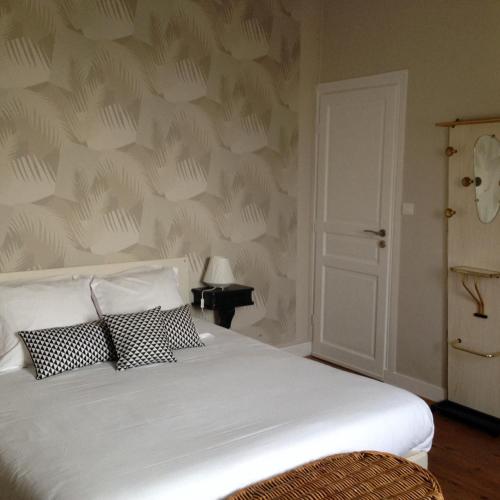 a bedroom with a white bed with two pillows at Maison Castel Braz in Pont-Aven
