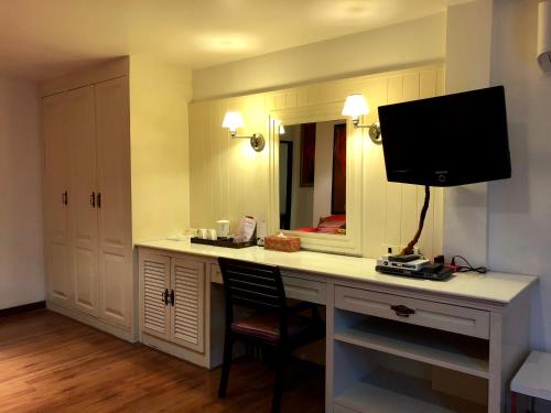 a room with a desk with a tv and a mirror at Baipho Lifestyle in Patong Beach
