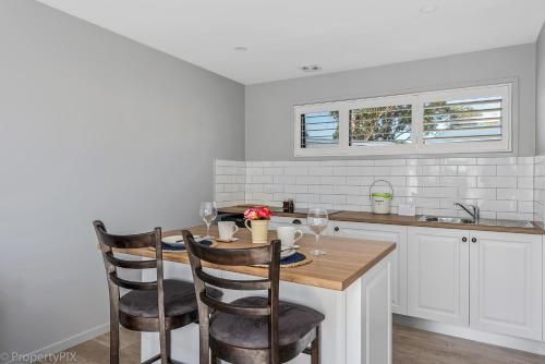 a kitchen with a wooden table and two chairs at Harrison Grove in Forcett