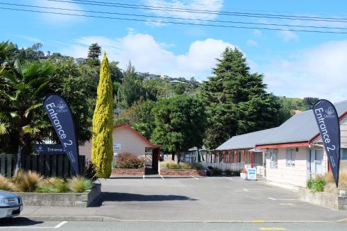 un parcheggio con cartelli di fronte a un edificio di Castles Motel & Driftwood Motel a Nelson