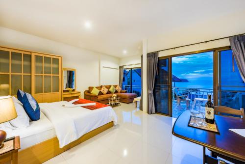 a bedroom with a bed and a view of the ocean at Da Bungalows in Kata Beach