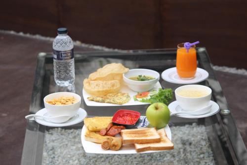 a tray with two plates of breakfast foods and a drink at Anchorage The Residence in Dhaka