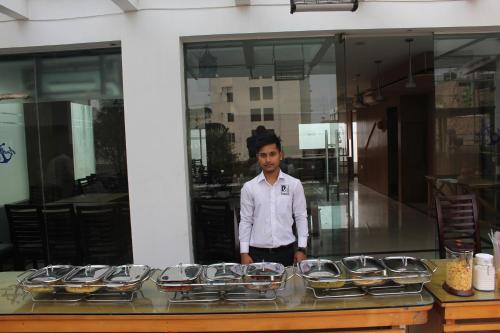 a man standing in front of a table of food at Anchorage The Residence in Dhaka