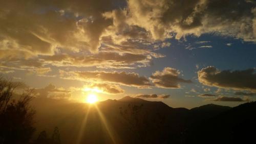 a sunset with the sun shining through the clouds at The fairy land - Lala Mountain in Fuxing