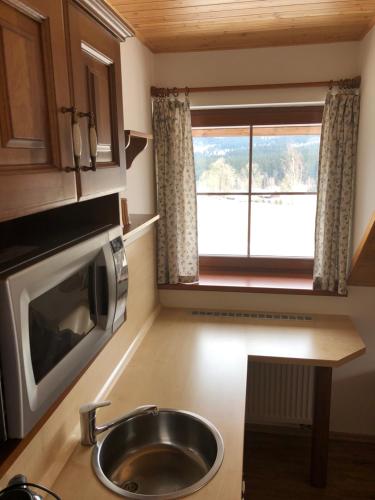 a small kitchen with a sink and a window at Penzion Pod Dratnikem in Svratka