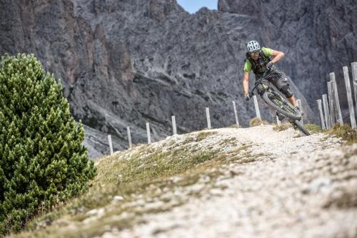 a man riding a bike down a hill at Linder Cycling Hotel in Selva di Val Gardena