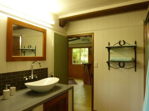 a bathroom with a sink and a mirror at The Stables in Cooroy