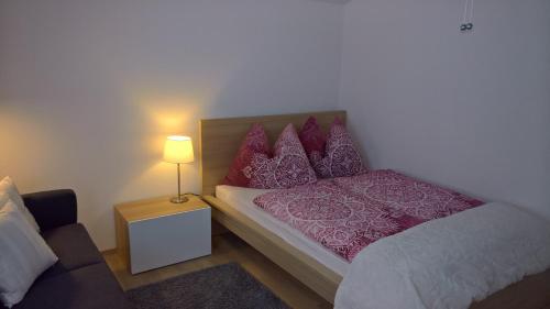 a small bedroom with a bed and a lamp at Appartement Erlbacher in Lungötz