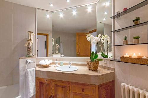 La salle de bains est pourvue d'un lavabo et d'un grand miroir. dans l'établissement Ca Na Rosa, à Selva
