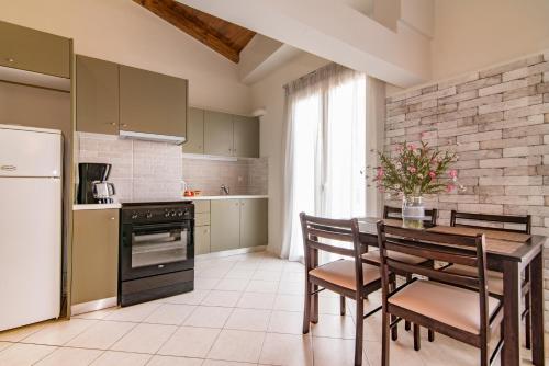 a kitchen with a table and chairs and a refrigerator at Semeli Apartment in Zakynthos