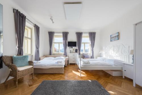 プラハにあるKafka Apartment with bridge viewのベッドルーム1室(ベッド2台、椅子付)
