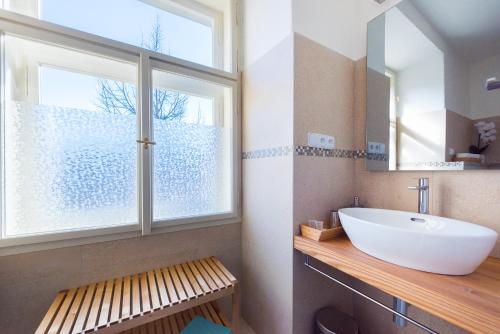 La salle de bains est pourvue d'un lavabo et d'une grande fenêtre. dans l'établissement Kafka Apartment with bridge view, à Prague