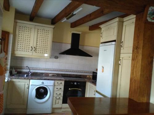 a kitchen with a white refrigerator and a dishwasher at Casa Llayo in Aliezo