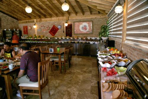 a dining room with people sitting at tables in a restaurant at Venus Hotel in Pamukkale