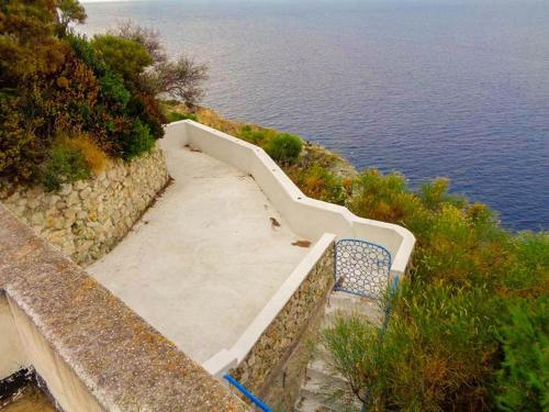 una scala con una panca accanto all'acqua di Maridea - Villetta La Sirenetta a Ponza