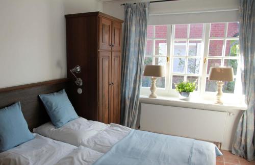 - une chambre avec 2 lits et une fenêtre dans l'établissement Greetsieler Landhaus, à Greetsiel