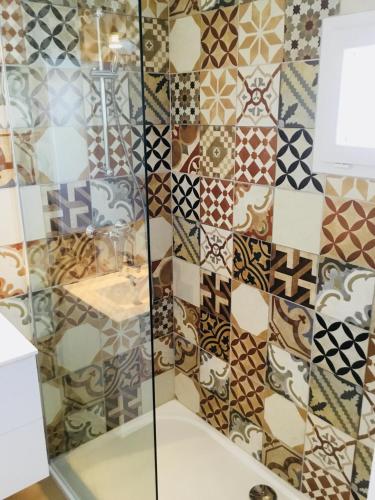 La salle de bains est pourvue d'une douche et de carrelage sur le mur. dans l'établissement Gite Blanco y Madera, à Narbonne