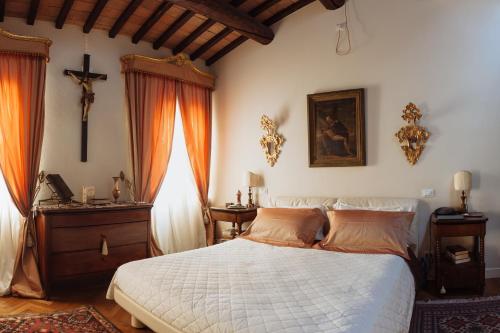 a bedroom with a bed and a cross on the wall at B&B Al Re in Cesena