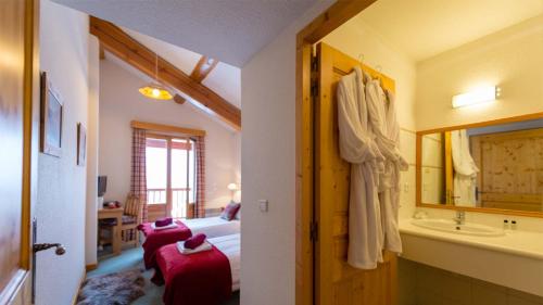 ein Bad mit einem Bett, einem Waschbecken und einer Badewanne in der Unterkunft Chalet Coeur des Brévières by Chalet Chardons in Tignes