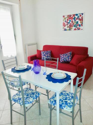 ネットゥーノにあるHome Sweet Seaの白いテーブル(椅子2脚付)と赤いソファ