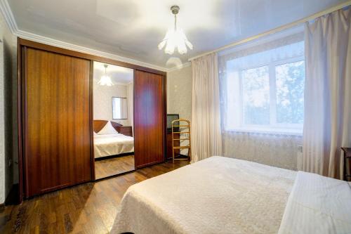 a bedroom with a large bed and a window at Apartament on Sovetskaya lux in Tomsk