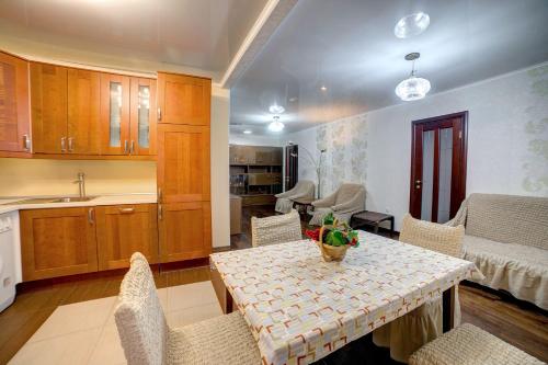 a kitchen and dining room with a table and chairs at Apartament on Sovetskaya lux in Tomsk