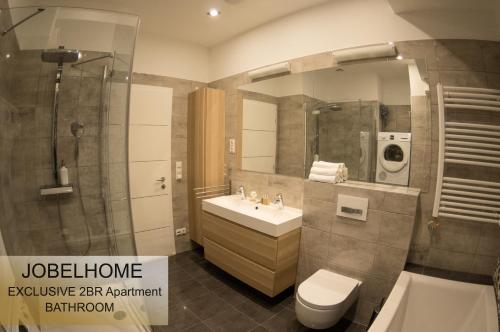布達佩斯的住宿－喬貝公寓，浴室配有卫生间、盥洗盆和淋浴。