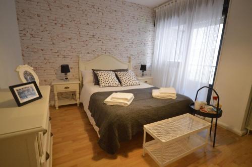 a bedroom with a bed and a brick wall at Apartamento Fleta in Zaragoza