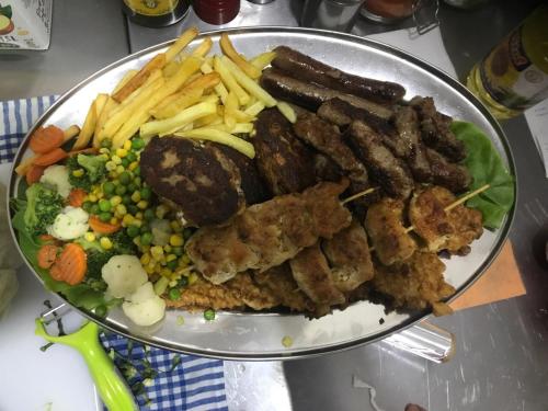 a plate of food with meat and french fries at B&B Hisar International in Prijepolje