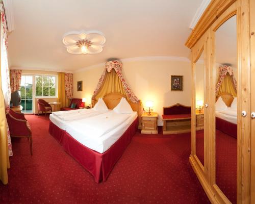 a hotel room with two beds and red carpet at Wohlfühlresort und Feriengut Martinerhof in Sankt Martin am Tennengebirge