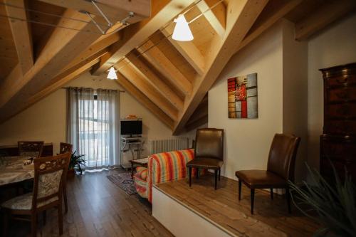 ein Wohnzimmer mit Holzdecken sowie einem Tisch und Stühlen in der Unterkunft Casa De Val in Calceranica al Lago