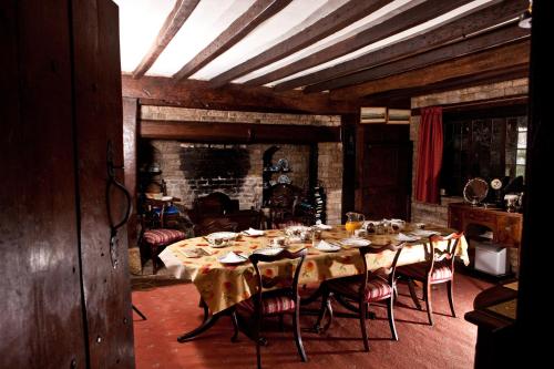 uma sala de jantar com uma mesa e cadeiras e uma lareira em Church Hill Farm em Lighthorne