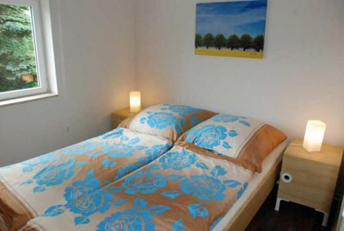 a bedroom with a bed with blue flowers on it at Ferienbungalow in Goehren in Göhren