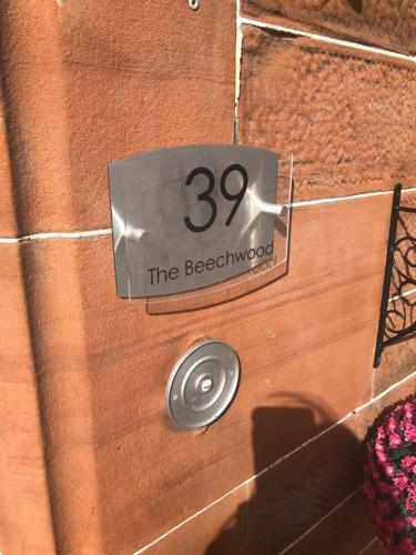 a wooden door with a sign that reads the beechwood at Beechwood Ensuite Guest House in Ayr