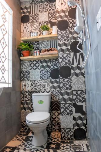 a bathroom with a toilet and black and white tiles at Vika Homestay in Ho Chi Minh City