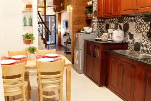 a kitchen with a wooden table and a kitchen with a sink at Vika Homestay in Ho Chi Minh City