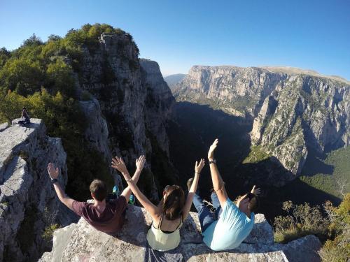 three people sitting on top of a mountain at Gaia Guesthouse in Dilofo