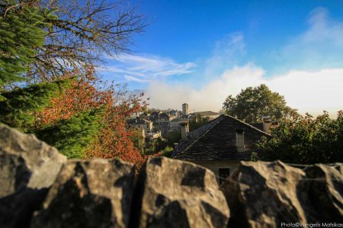 a view from behind a stone fence of a house at Gaia Guesthouse in Dilofo