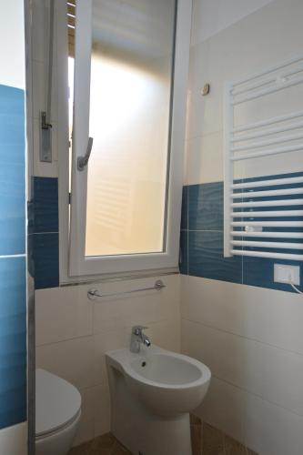 a bathroom with a toilet and a sink and a window at Palafiori Rooms Sanremo in Sanremo