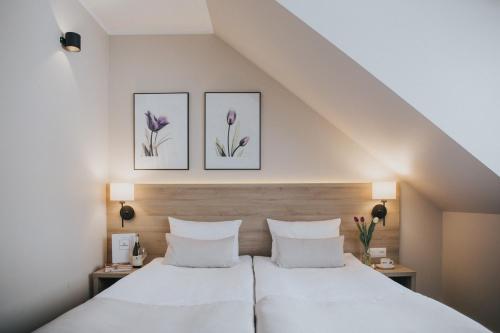 a bedroom with two beds with purple flowers on the wall at Tulipanowy Gościniec in Jantar