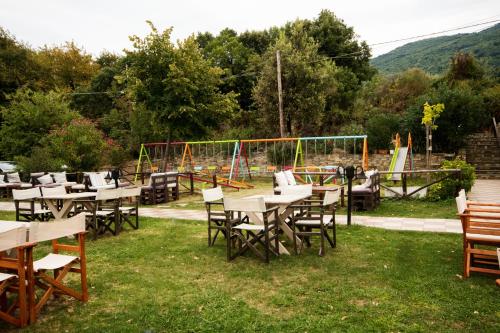a group of tables and chairs with a playground at Hotel Vlassis in Stómion