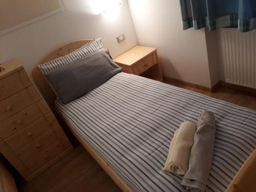a bedroom with a large bed with a blue striped bedspread at HartlHof in Proves