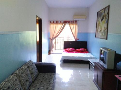 a living room with a bed and a television at Sanie Guest Room Suria A' Apartment, Bukit Merah Laketown Resort in Kampong Kubu Gajah