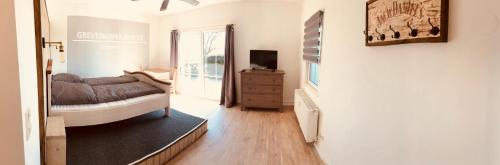 a bedroom with a bed and a television in a room at Apartment Lotti in Grevenkop
