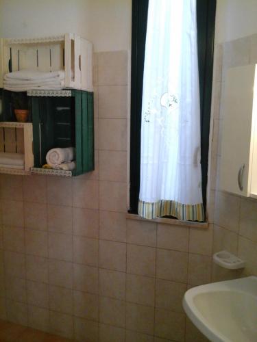 a bathroom with a sink and a shower curtain at Villetta al mare in Marsala