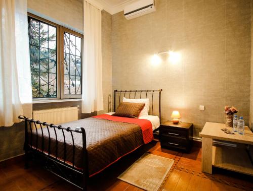 a small bedroom with a bed and a window at Hotel Toma's House in Tbilisi City