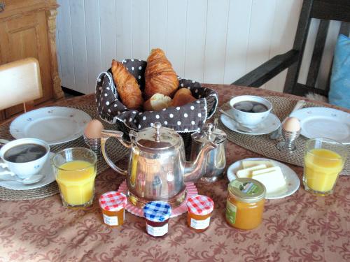 una mesa de desayuno con una cesta de pan y huevos en Ranch Bignaou, en Amou