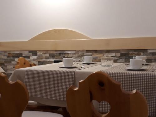 a table with a white table cloth and cups on it at HartlHof in Proves