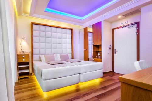 a bedroom with a white bed and a purple ceiling at Porto Marine Hotel in Platamonas