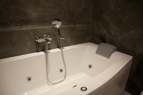 a white bath tub with a shower in a bathroom at B&B Mare di Fuori in Stintino